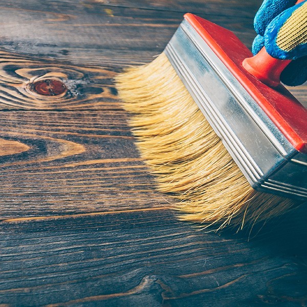 Hand brush covers with oil old wooden floor - repair and restoration of the floor